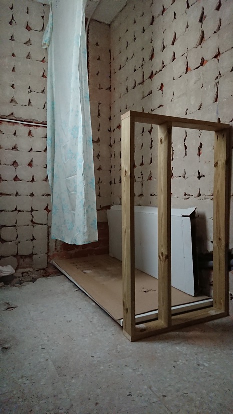 Bastidor de madera situado entre la zona de ducha y la del lavabo.