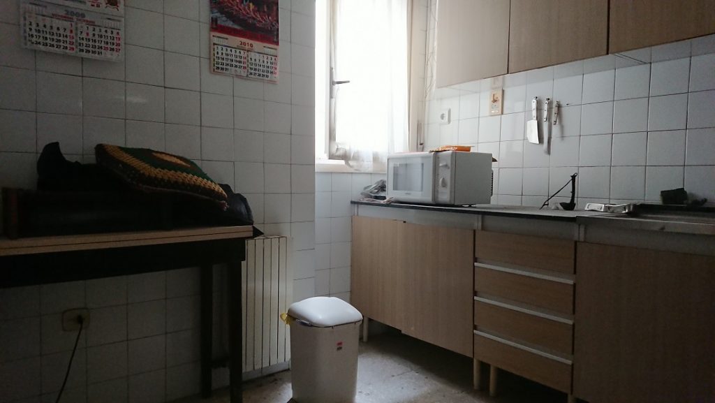 Cocina original con muebles altos y bajos, encimera y revestimientos antiguos.