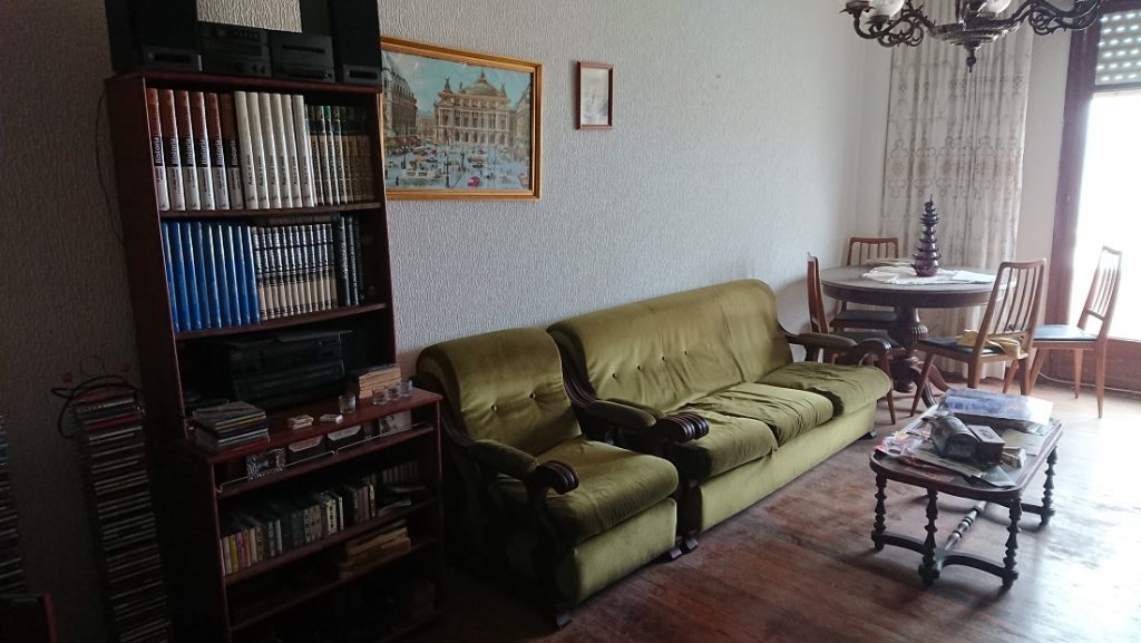 Gran mueble de madera del salón, con vitrinas y módulos junto al sofá.