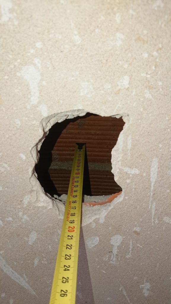 Abertura en una pared con una cinta métrica junto al hueco de la cámara.