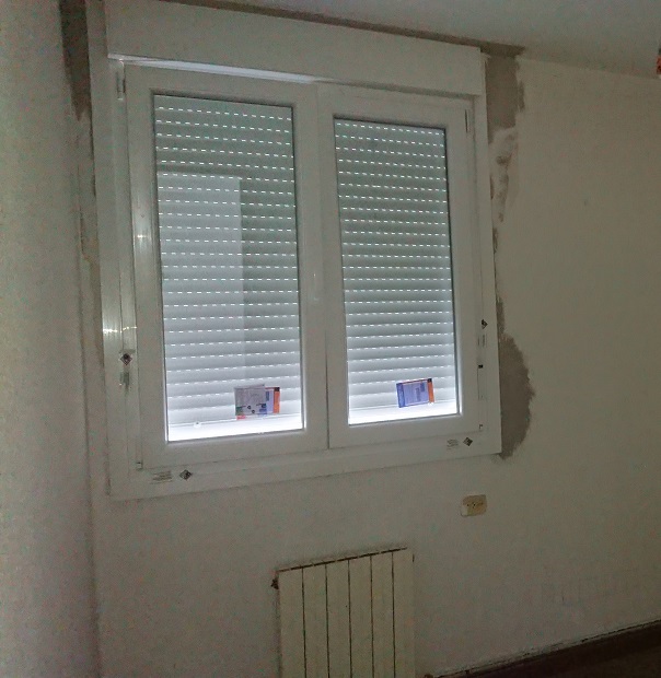 Ventana nueva de PVC blanco colocada sobre el hueco de un radiador.
